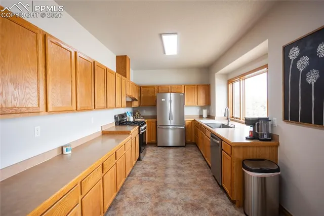a kitchen with sink a counter top space and stainless steel appliances