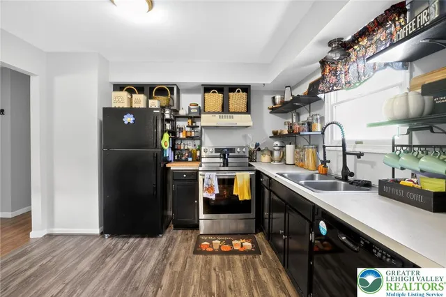 a kitchen with stainless steel appliances granite countertop a refrigerator a sink and wooden cabinets