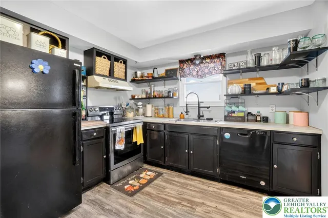 a kitchen with stainless steel appliances granite countertop a refrigerator and wooden cabinets