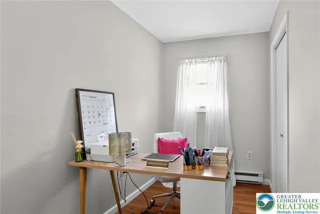 a view of a workspace with furniture and a window