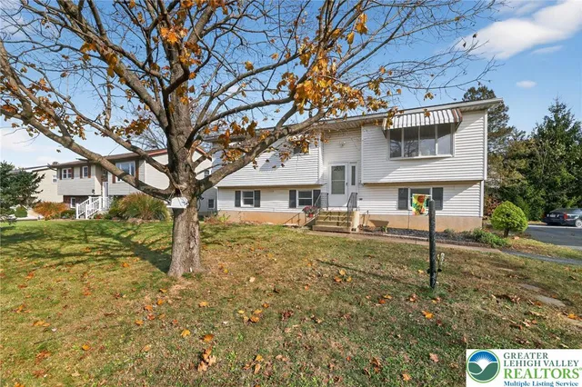 a white house that has a tree in front of it