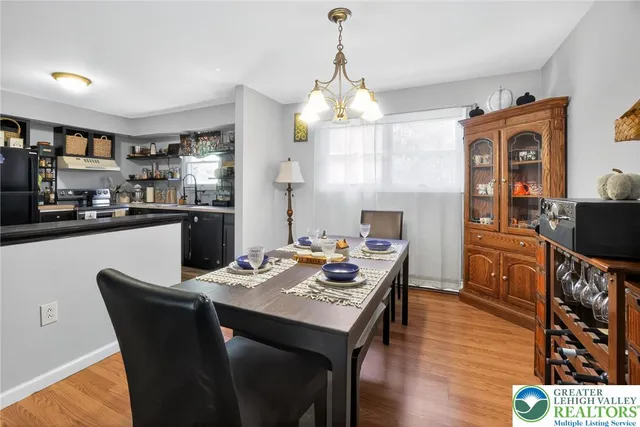 a view of a dining room with furniture a chandelier and wooden floor