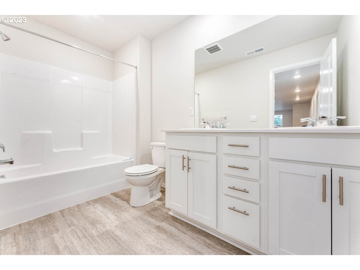 5629 Earth Street Northeast Dallas, OR 97338 - Photo 17 of 35 a bathroom with a toilet a sink a mirror a bathtub and vanity