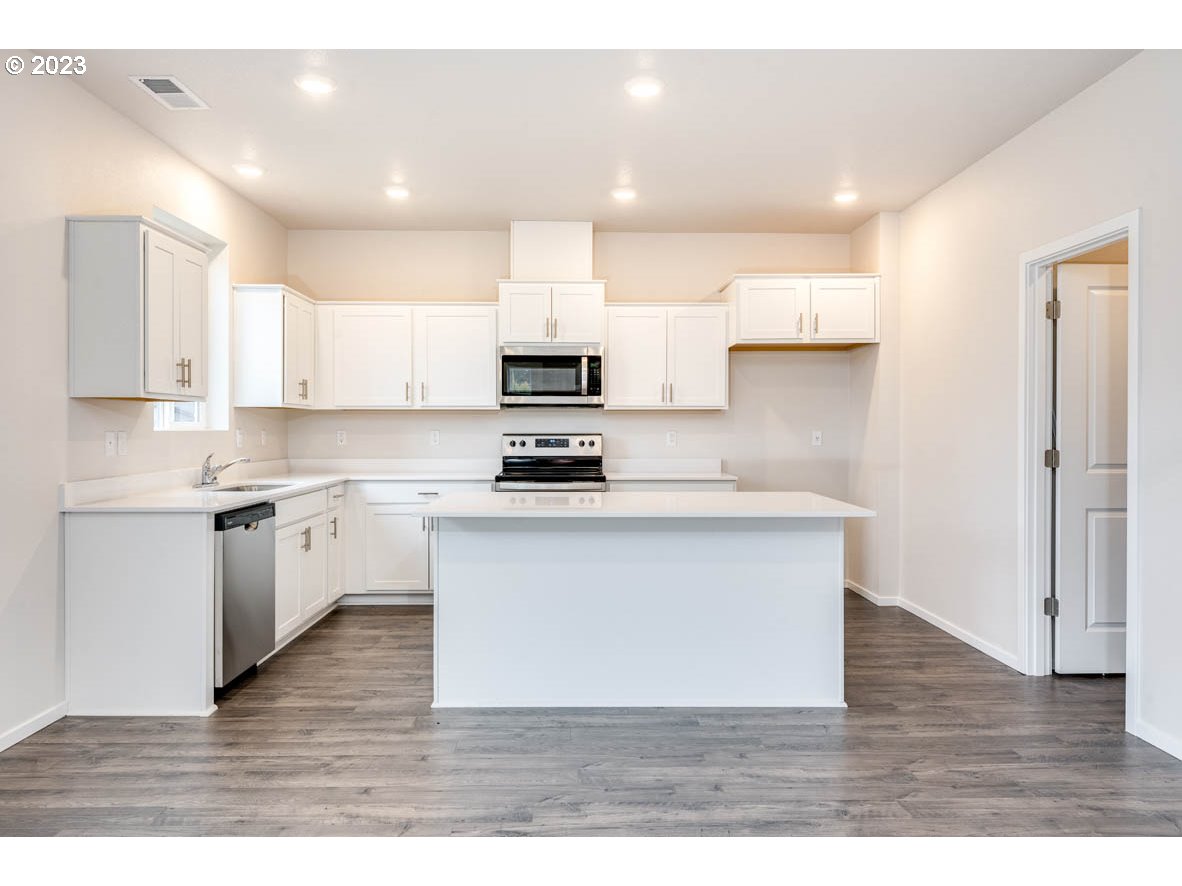 5629 Earth Street Northeast Dallas, OR 97338 - Photo 8 of 35 a kitchen with stainless steel appliances wooden floors and view living room