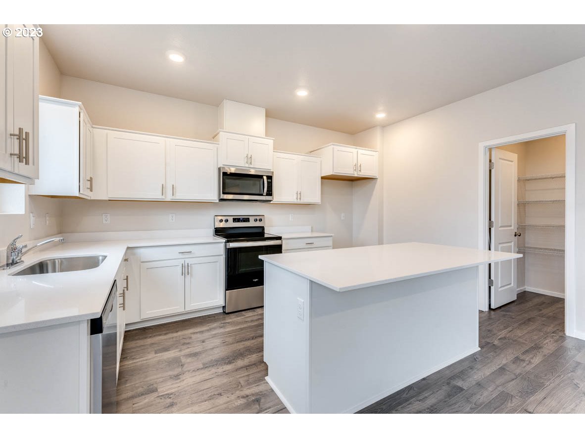 5629 Earth Street Northeast Dallas, OR 97338 - Photo 9 of 35 a kitchen with a sink a stove top oven and white kitchen
