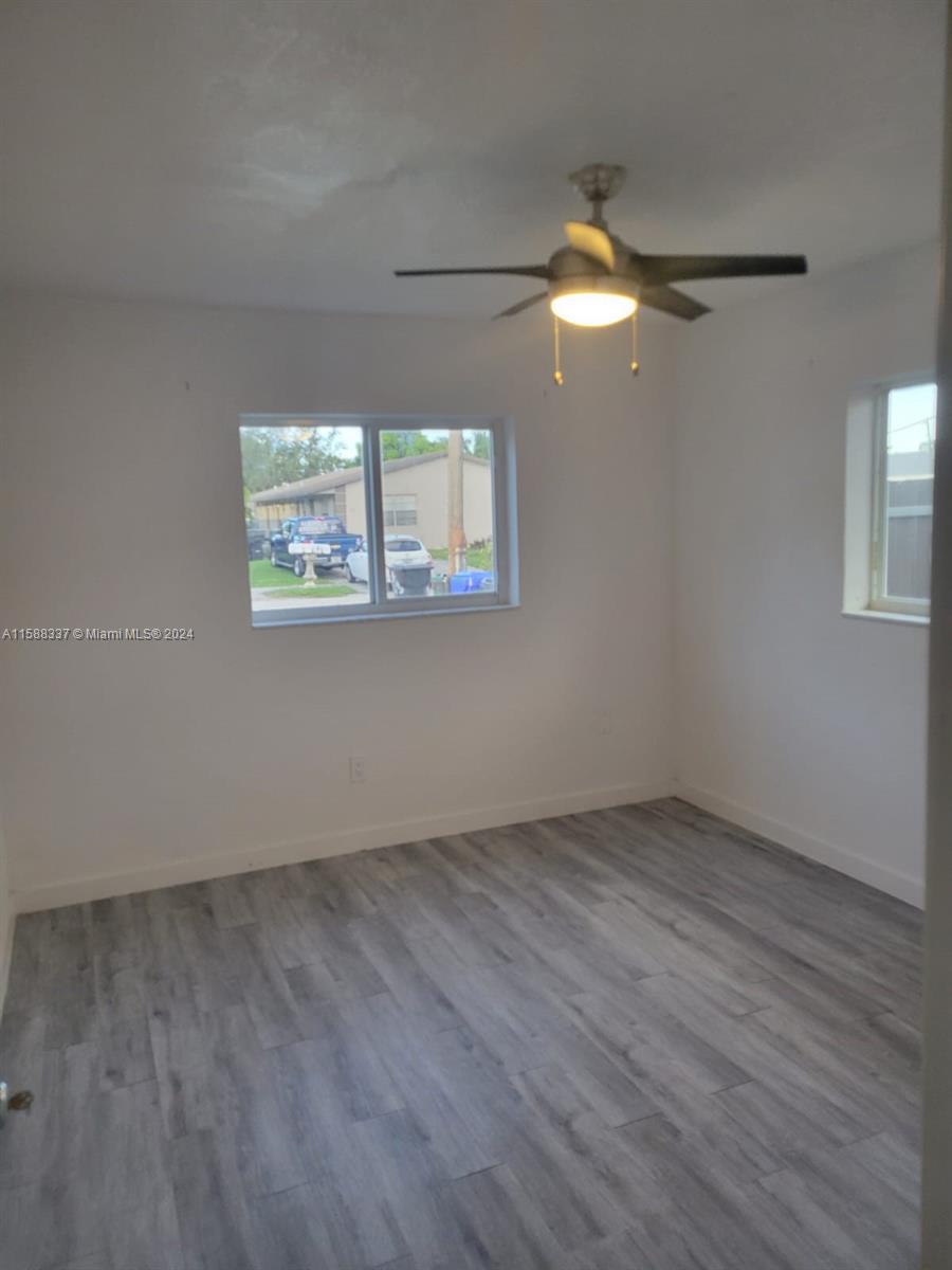 5922 Pierce Street, Unit 1 Hollywood, FL 33021 - Photo 2 of 7 an empty room with wooden floor and windows