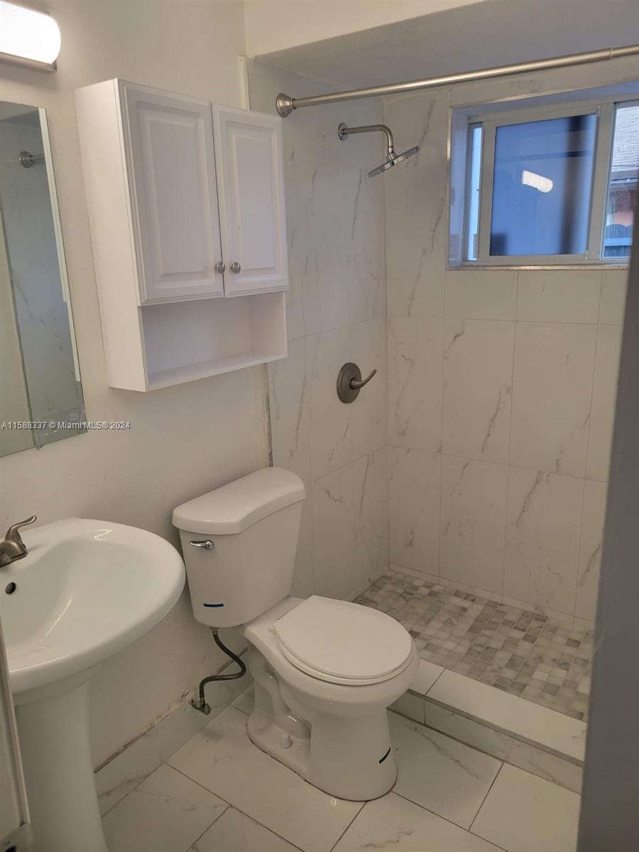 5922 Pierce Street, Unit 1 Hollywood, FL 33021 - Photo 5 of 7 a white toilet sitting next to a bath tub