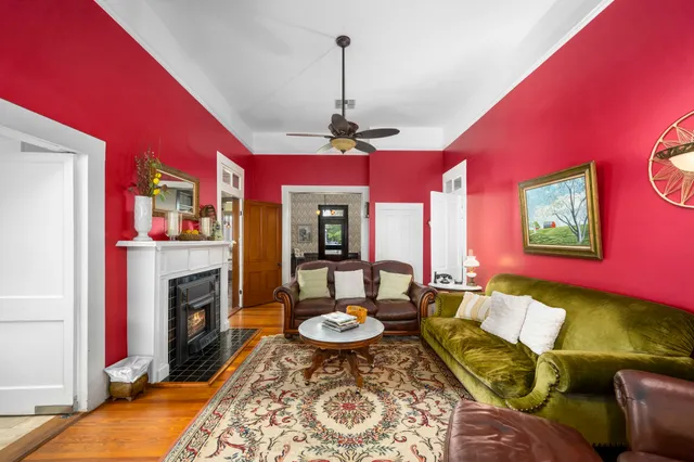 a view of a dining room with furniture a fireplace and wooden floor