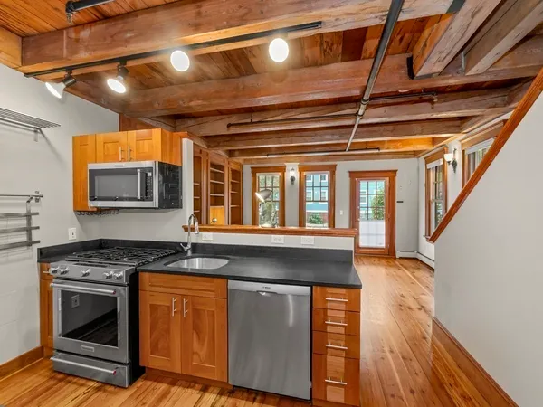 a kitchen with granite countertop a stove and a wooden floor