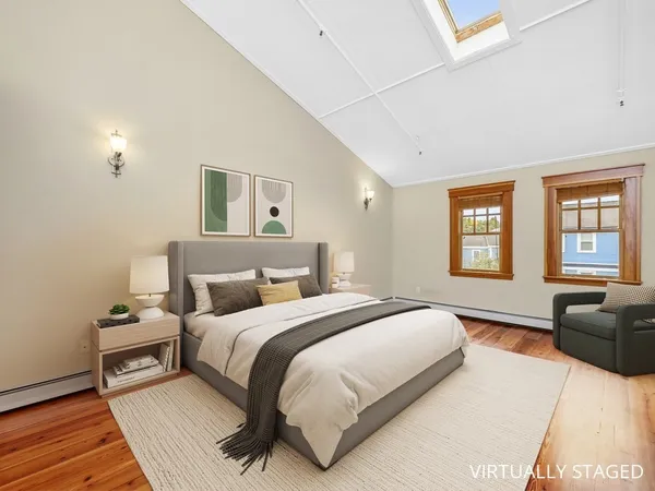 a spacious bedroom with a bed and wooden floor