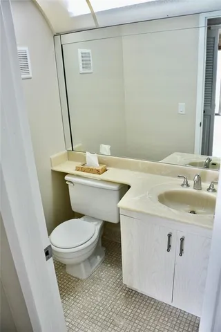 a bathroom with a toilet and a mirror