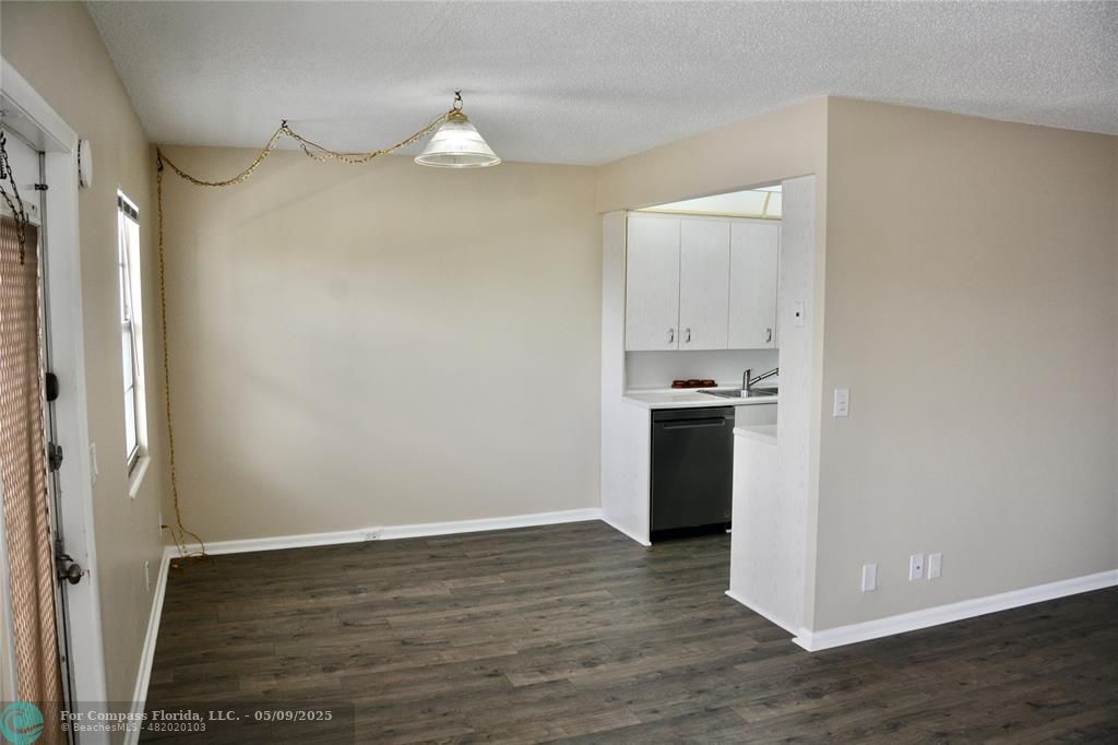4070 Exeter Boca Raton, FL 33434 - Photo 4 of 59 a view of an empty room with wooden floor and a kitchen