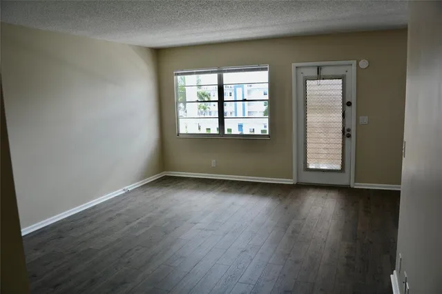 an empty room with wooden floor and window