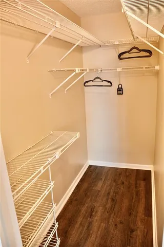 a view of a room with empty space and wooden floor
