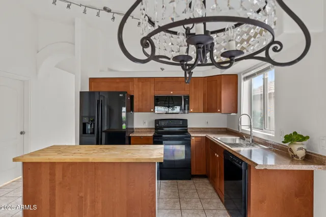 a kitchen with stainless steel appliances granite countertop a refrigerator a sink dishwasher a oven with a dining table and chairs