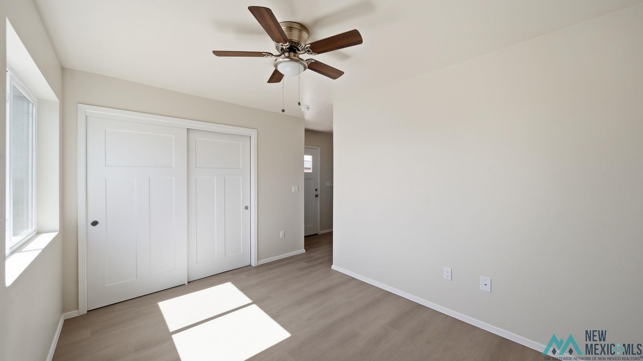 106 Inca Street Elephant Butte, NM 87935 - Photo 32 of 36 Unfurnished bedroom featuring a closet, light wood-type flooring, and a ceiling fan