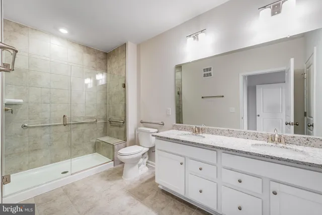 a spacious bathroom with a granite countertop sink toilet mirror and bathtub