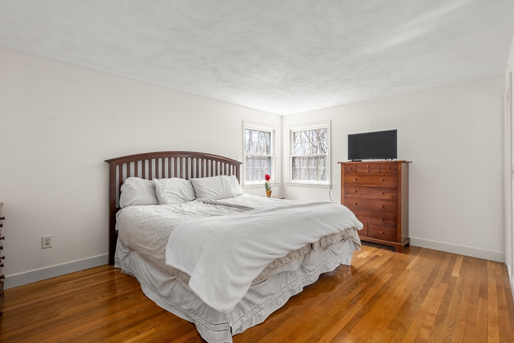39 Dakin Road Sudbury, MA 01776 - Photo 13 of 34 a bedroom with a bed and wooden floor