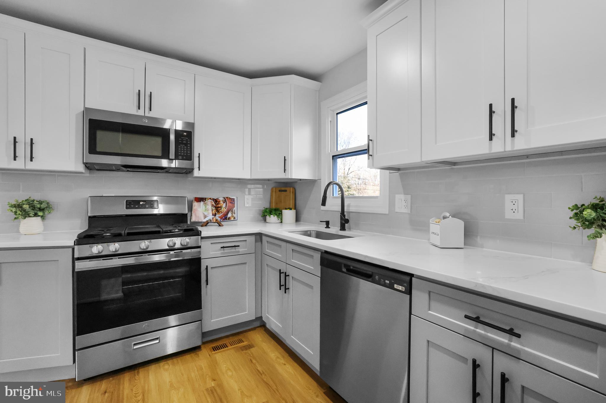 4305 Garrett Park Road Silver Spring, MD 20906 - Photo 15 of 39 a kitchen with stainless steel appliances granite countertop a sink a stove a microwave and cabinets