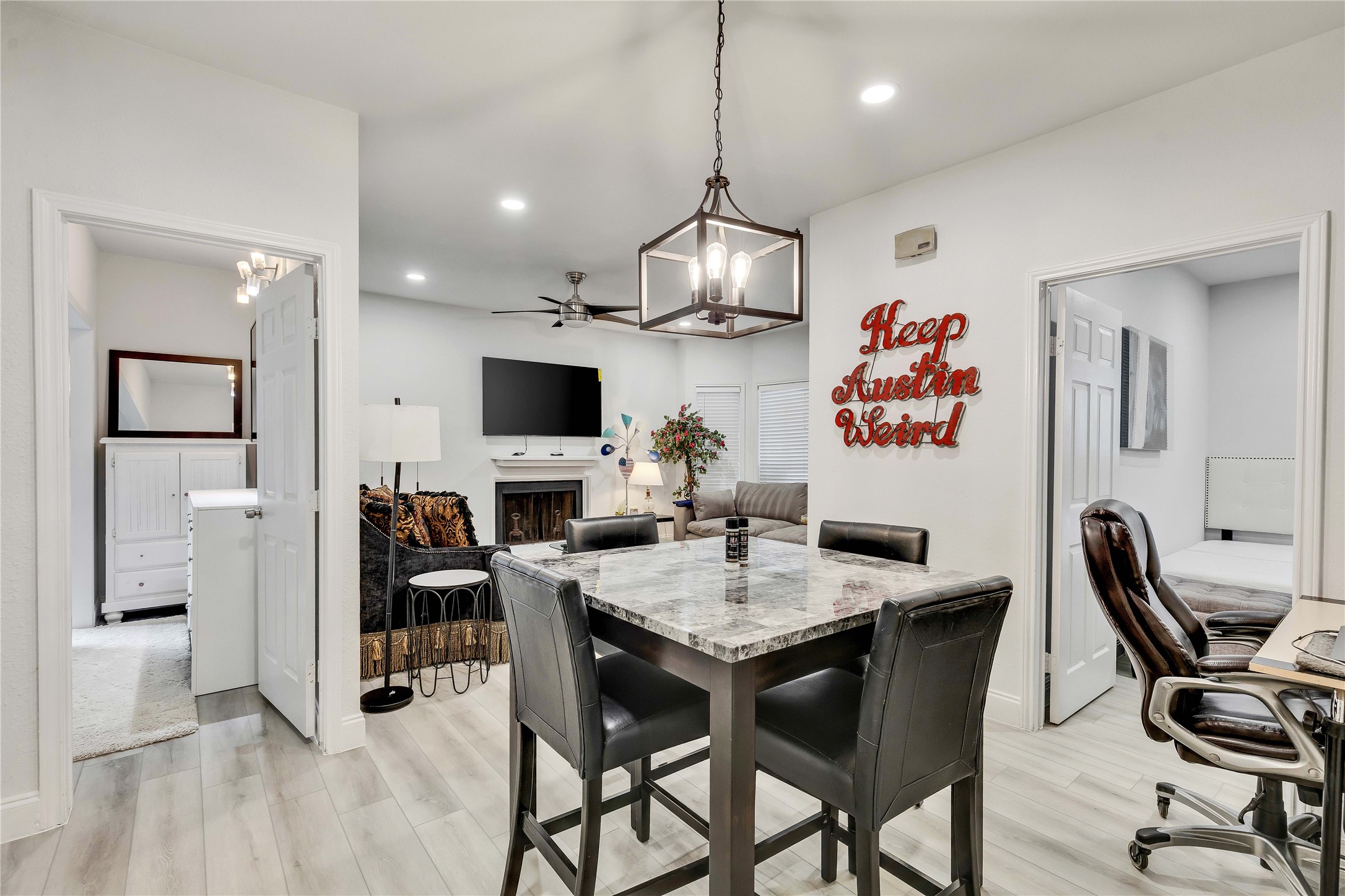 2529 Rio Grande Street, Unit 56 Austin, TX 78705 - Photo 6 of 16 Dining room featuring light wood finished floors, a fireplace, ceiling fan with notable chandelier, and recessed lighting