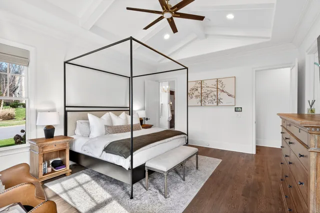 a bedroom with a bed couch and large window