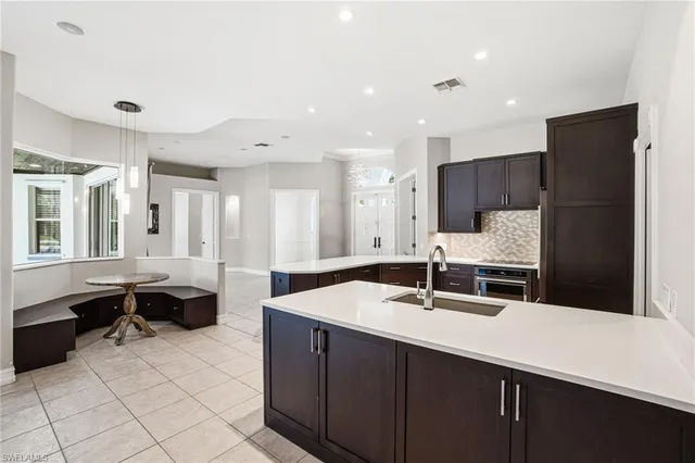 a kitchen with a sink and chairs