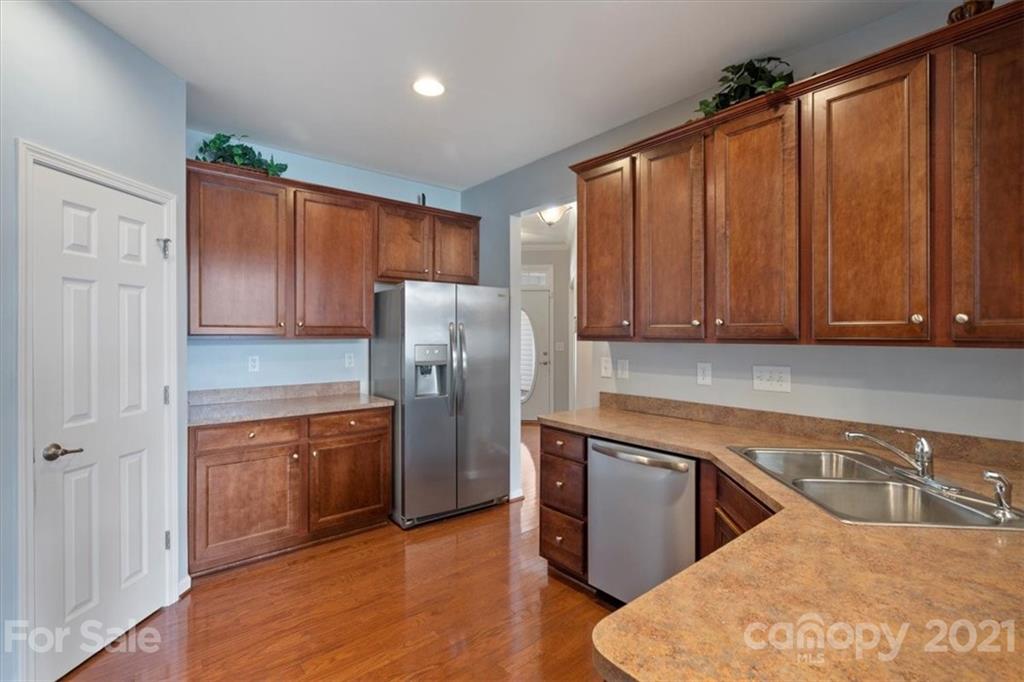 257 Garnet Court Fort Mill, SC 29708 - Photo 31 of 43 a kitchen with stainless steel appliances granite countertop a refrigerator a sink dishwasher and wooden cabinets with wooden floor