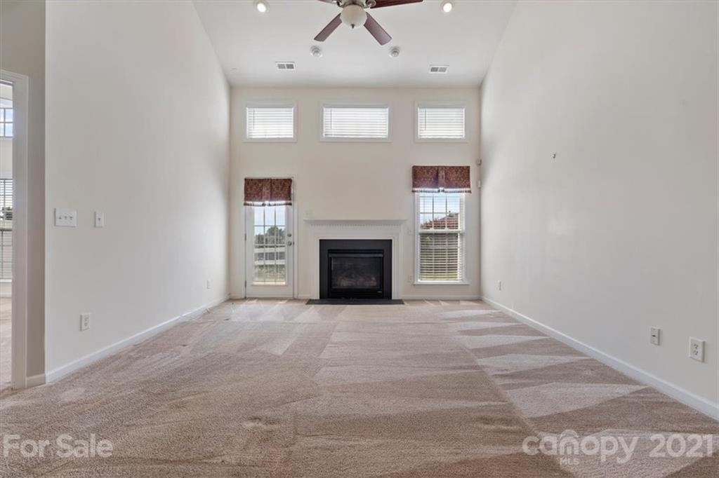 257 Garnet Court Fort Mill, SC 29708 - Photo 9 of 43 an empty room with windows and fireplace