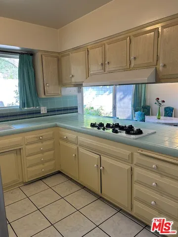 a kitchen with granite countertop white cabinets and white appliances