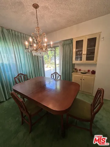 a dining room with furniture a chandelier and window