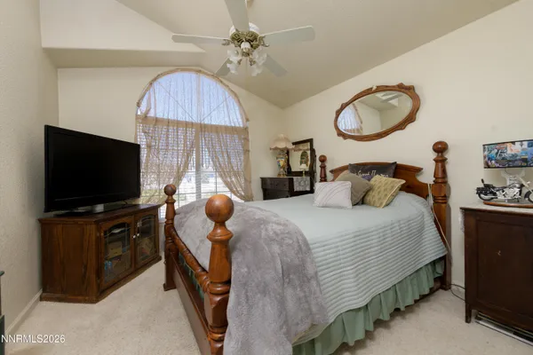 a bedroom with bed and flat tv screen on dresser