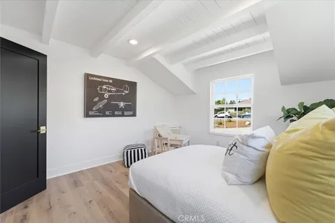 a bedroom with a bed and painting on the wall