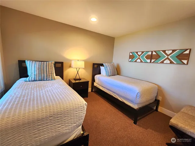 a bedroom with two beds and painting on the wall