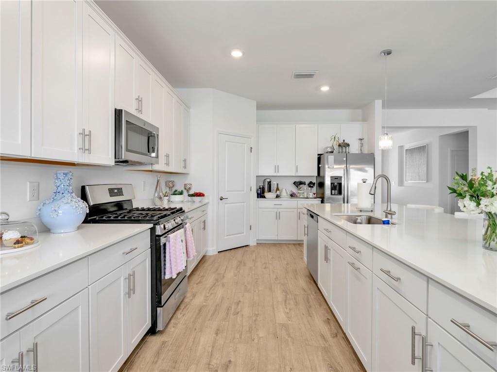 18278 Ridgeline Drive Estero, FL 33928 - Photo 8 of 45 a large kitchen with stainless steel appliances granite countertop a lot of counter space and wooden floors