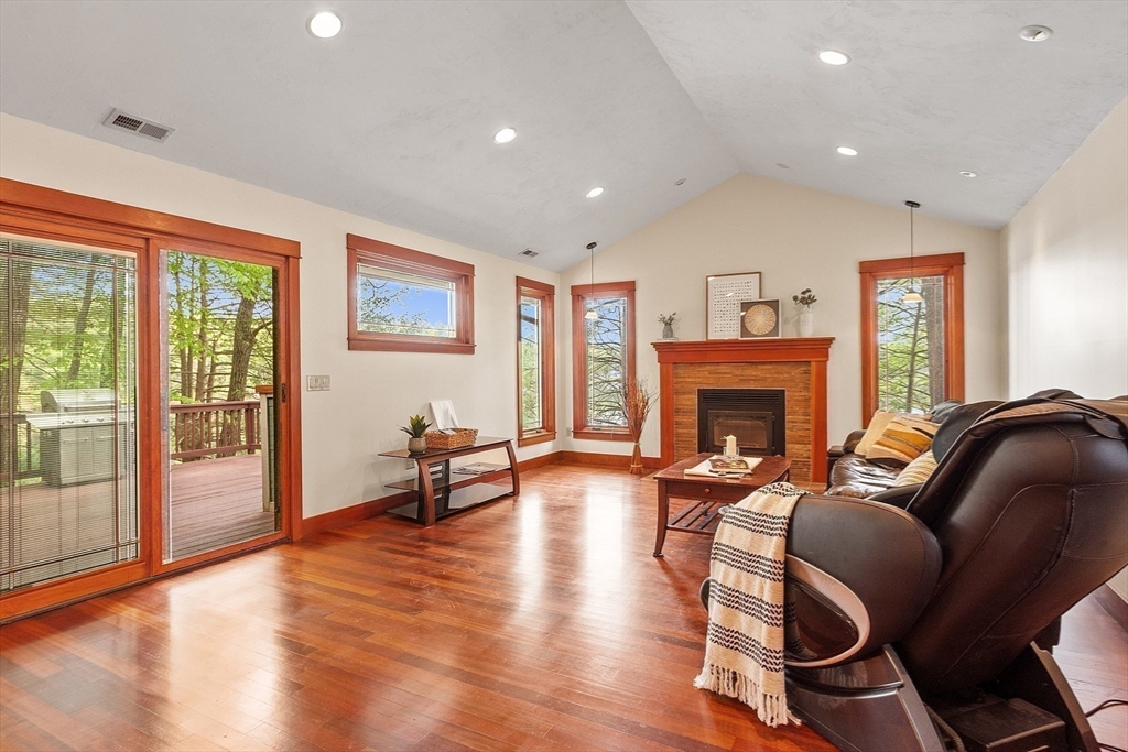 260 Fort Pond Road Lancaster, MA 01523 - Photo 8 of 41 a living room with furniture a fireplace and a floor to ceiling window