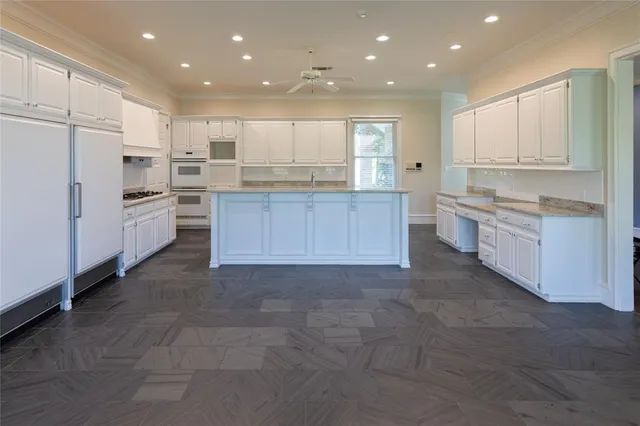 a large kitchen with kitchen island a sink a stove and a refrigerator