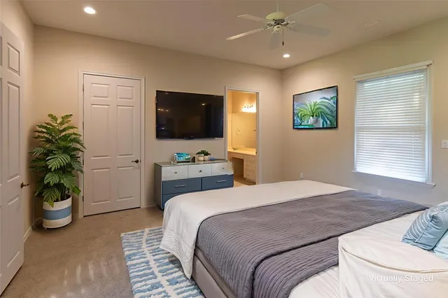 a bedroom with a bed a window and a flat screen tv