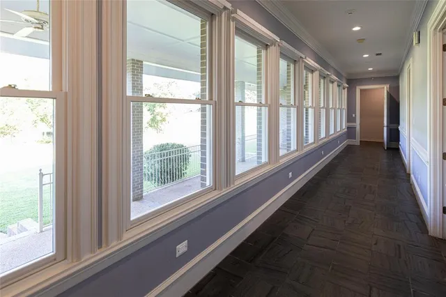 a view of a large room with wooden floor and windows