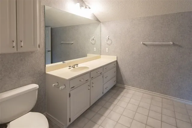 a spacious bathroom with a toilet sink and mirror