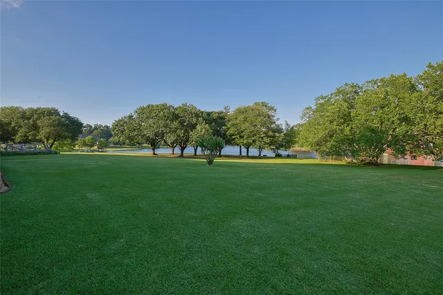 a view of grassy field with benches and trees all around