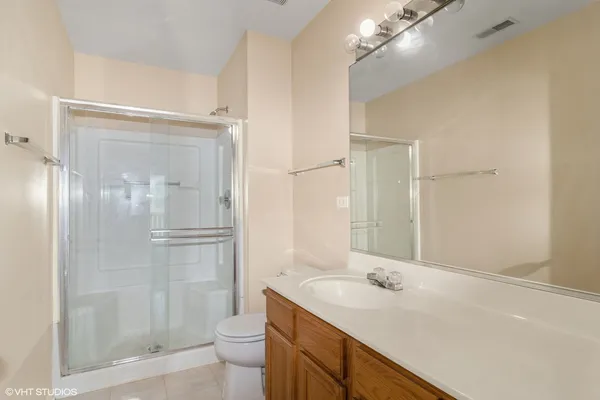 a bathroom with a shower sink vanity mirror and toilet