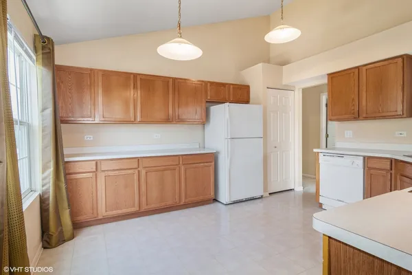 a kitchen with refrigerator a microwave and cabinets