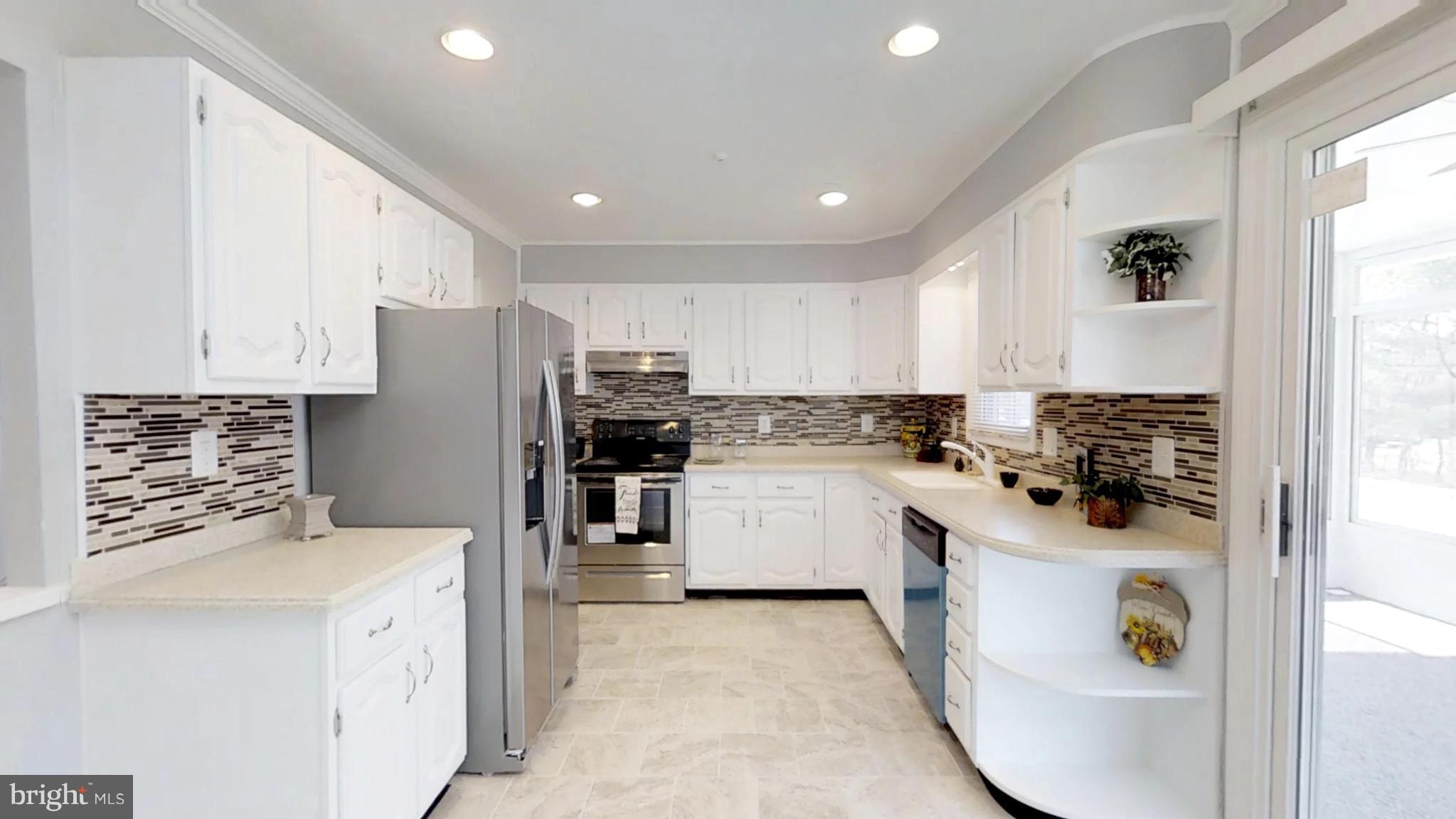 7764 Telegraph Road Severn, MD 21144 - Photo 1 of 24 a kitchen with white cabinets and stainless steel appliances
