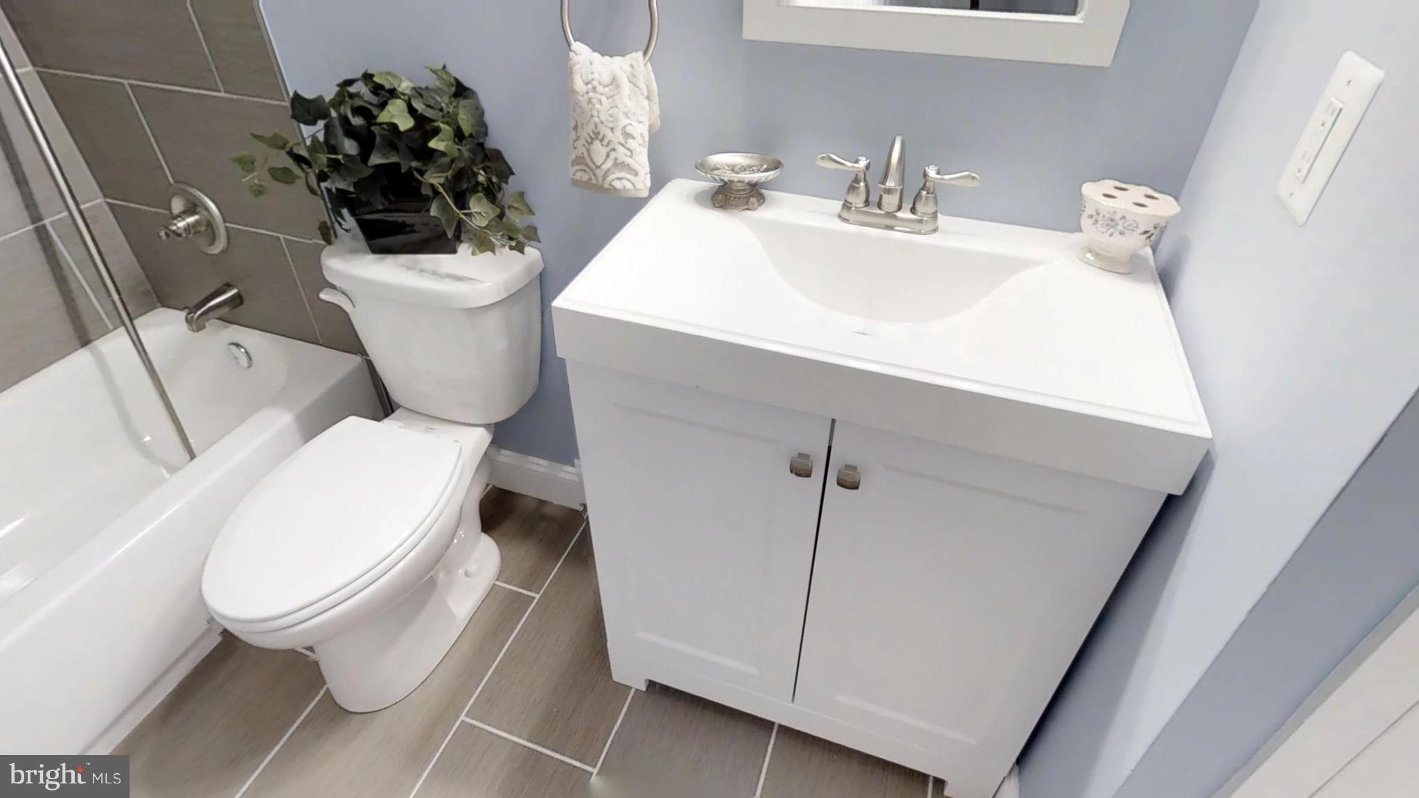 7764 Telegraph Road Severn, MD 21144 - Photo 18 of 24 a white toilet sitting next to a bathroom sink