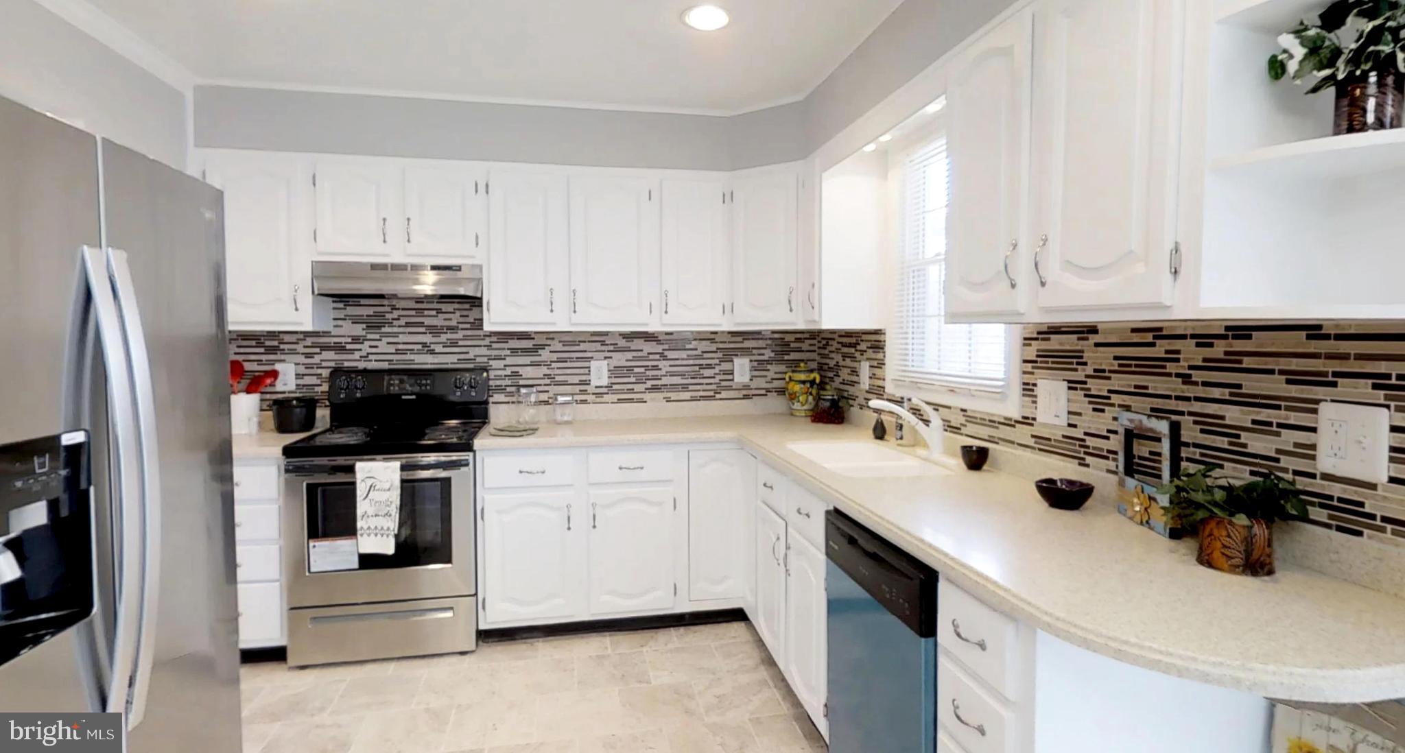 7764 Telegraph Road Severn, MD 21144 - Photo 3 of 24 a kitchen with stainless steel appliances a stove a sink a refrigerator and cabinets