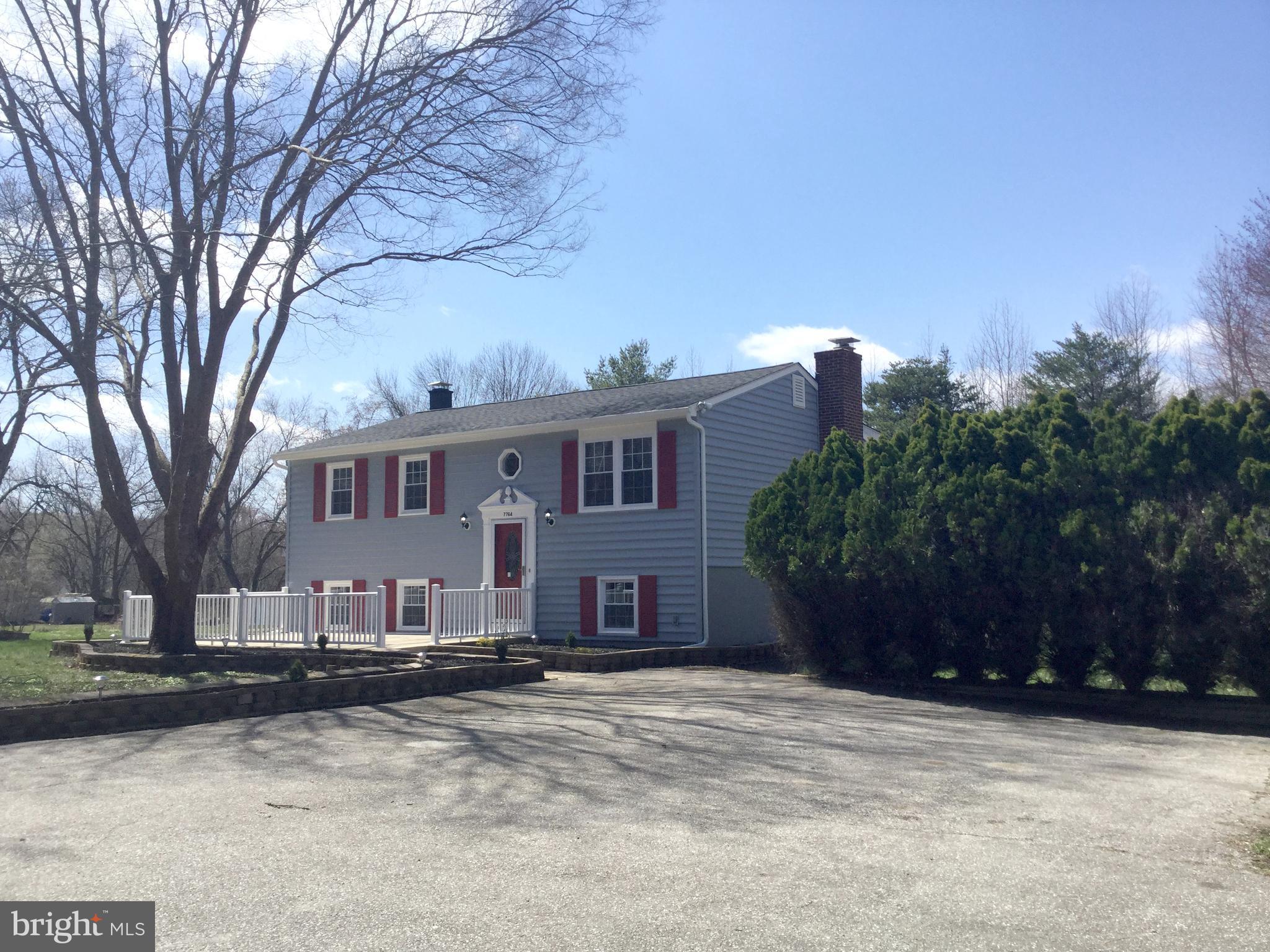7764 Telegraph Road Severn, MD 21144 - Photo 21 of 24 a front view of a house with a yard covered with snow and trees