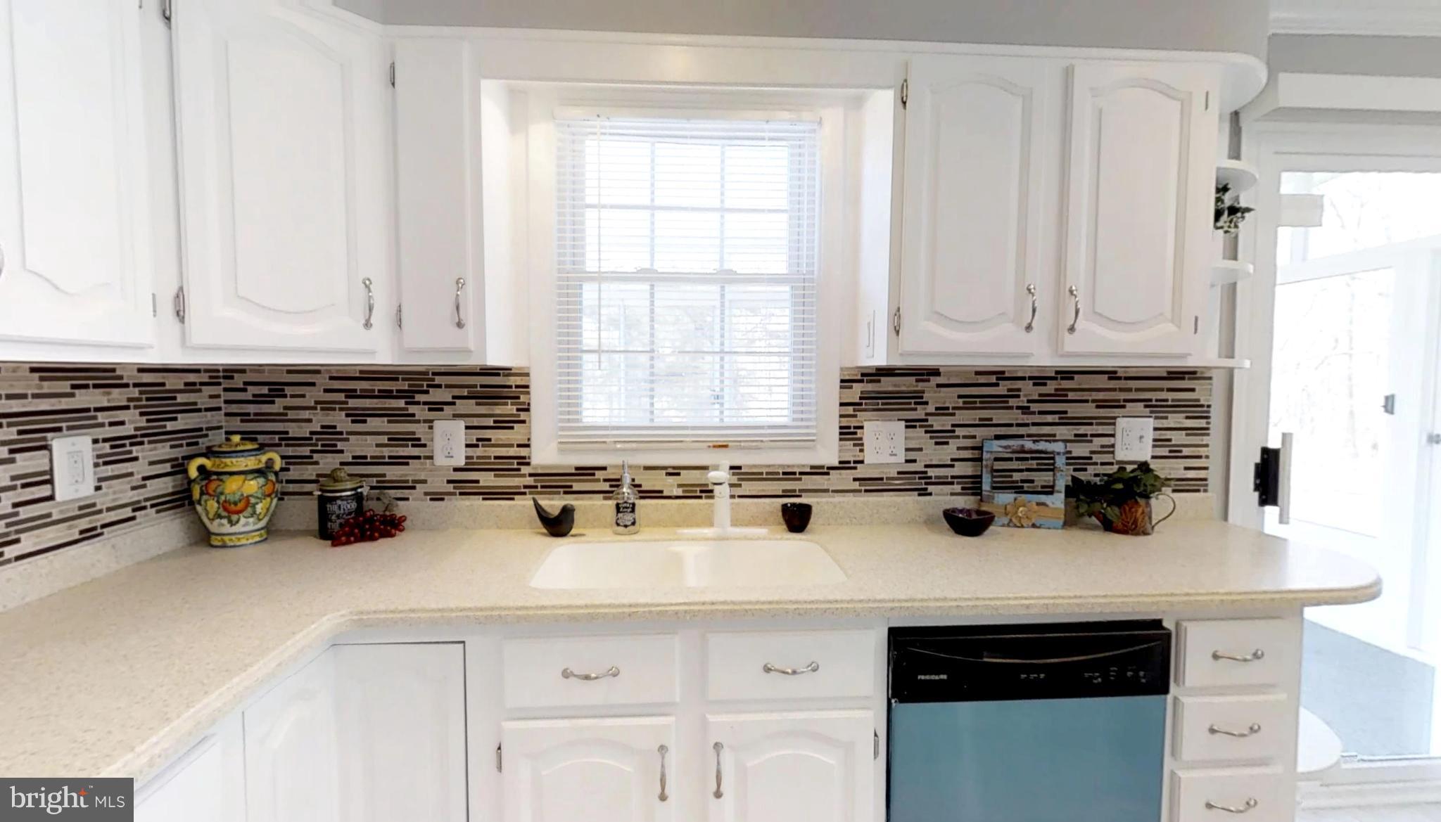 7764 Telegraph Road Severn, MD 21144 - Photo 6 of 24 a kitchen with a sink white cabinets and white appliances
