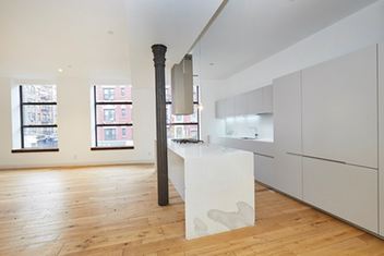 a kitchen with a wooden floor and a refrigerator
