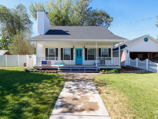 270 East 100 North Monroe, UT 84754 - Photo 1 of 65 White siding residence featuring a covered front porch, black window shutters, and a vibrant blue entry door