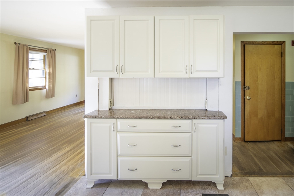 84 Bethany Road Framingham, MA 01702 - Photo 11 of 38 a kitchen with granite countertop white cabinets and a wooden floor